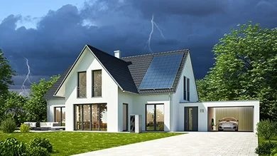 Das Bild zeigt ein Haus bei Gewitter. In der Garage steht ein Elektro-Auto, das an einer Wallbox aufgeladen wird. Auf dem Dach befindet sich eine Photovoltaikanlage.