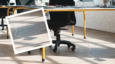Schreibtisch und schwarzer Bürostuhl leicht von unten fotografiert.